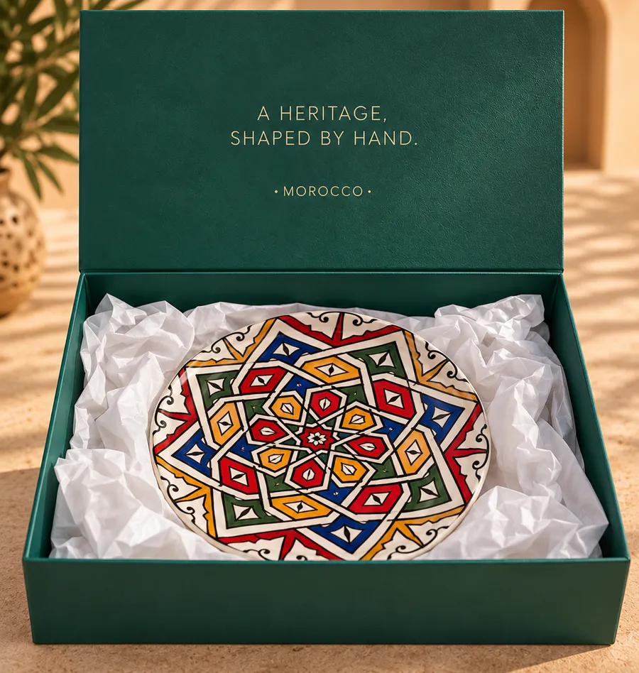 Assiette décorative peinte à la main d'un motif d'étoile multicolore, dans un coffret vert foncé